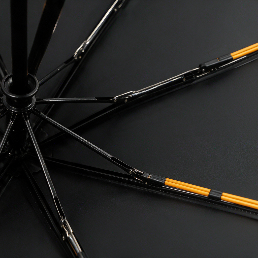 Close-up of the Ombriel Loop frame from inside the canopy: black alloy ribs with orange fibreglass strips, springs and joints around the hub